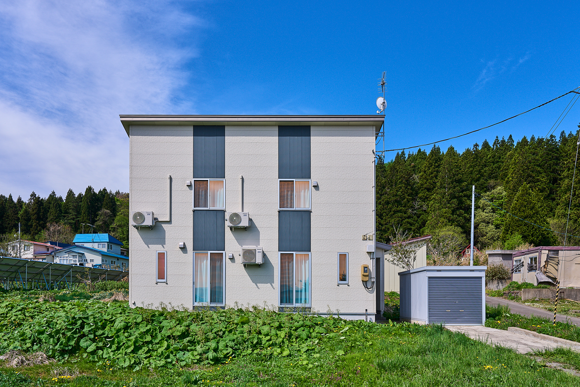 青空に映える一棟貸しの戸建て。緑豊かな静かなエリアに建つ一軒家
